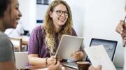 2 students talking and taking notes